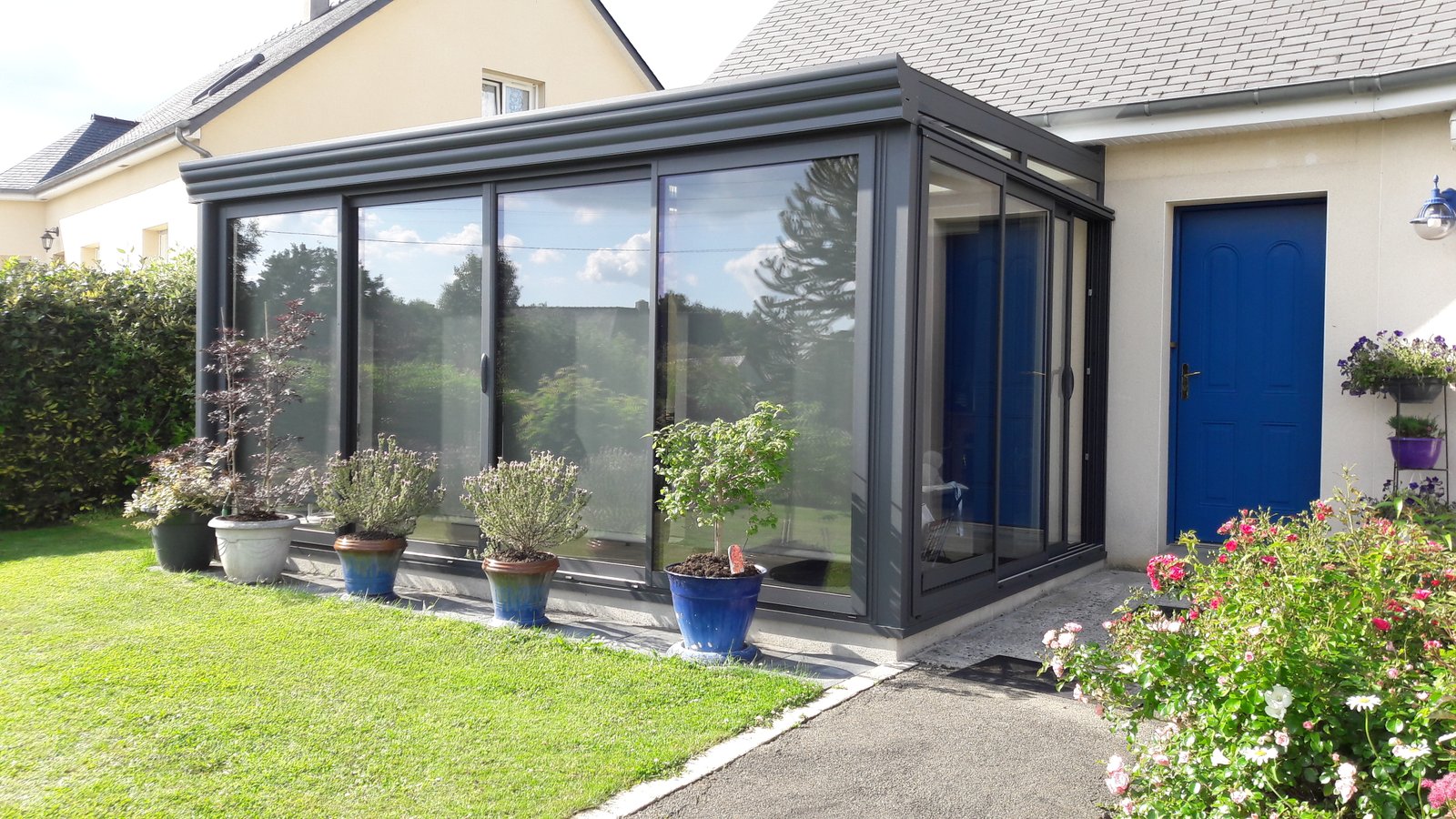 Grande véranda aluminium panoramique avec porte bleue — LG ALU