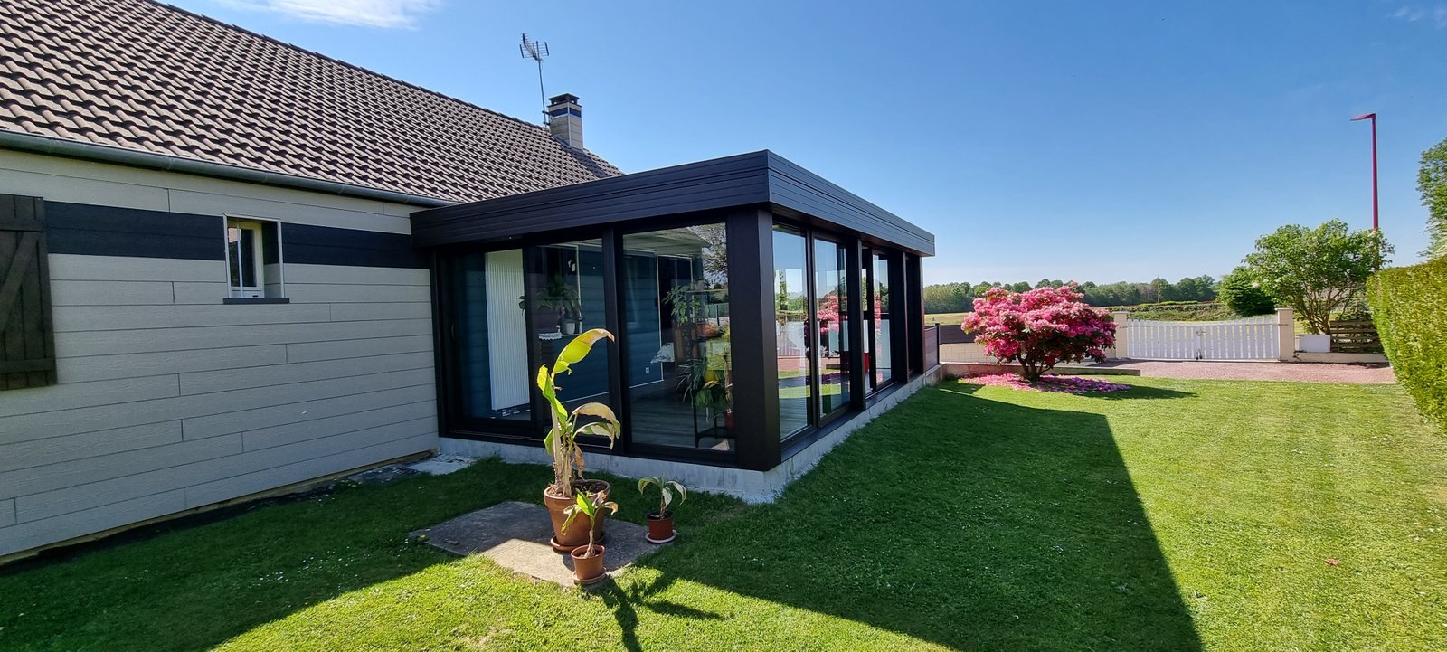 Véranda aluminium noir mat fond de jardin — LG ALU Menuiserie